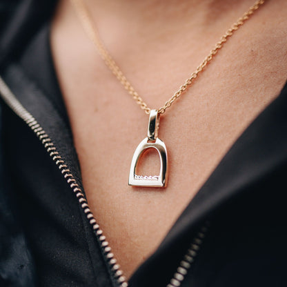 Small gold stirrup pendant worn by a horse rider made by Crawford Hill Equestrian Jewellery.
