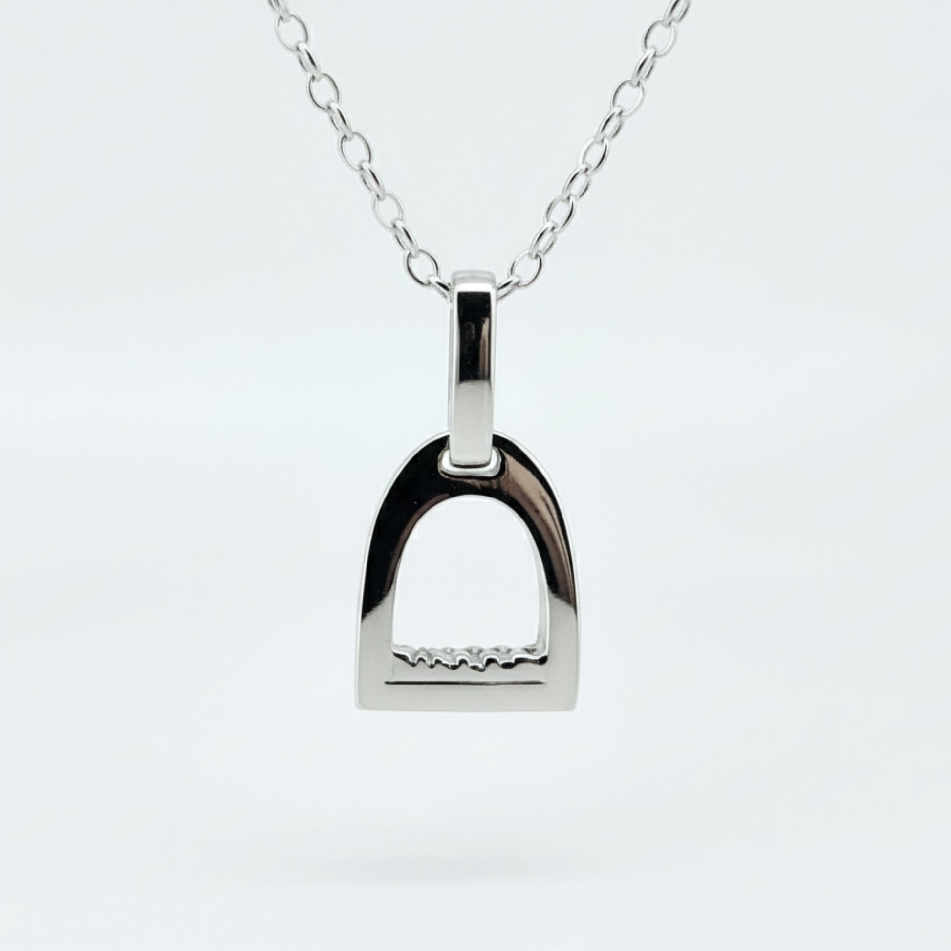 Product photo of small white gold stirrup necklace. Made to be worn by horse riders by Crawford Hill Equestrian Jewellery.